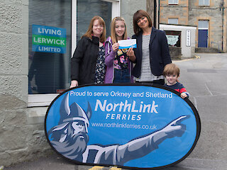 Photo: ©Ben Mullay. From left to right: Tracy Lobban, Karen Lobban (14), Cynthia Adamson (Manager at M & Co and Vice Chair at Living Lerwick) and Tom Lobban (4)